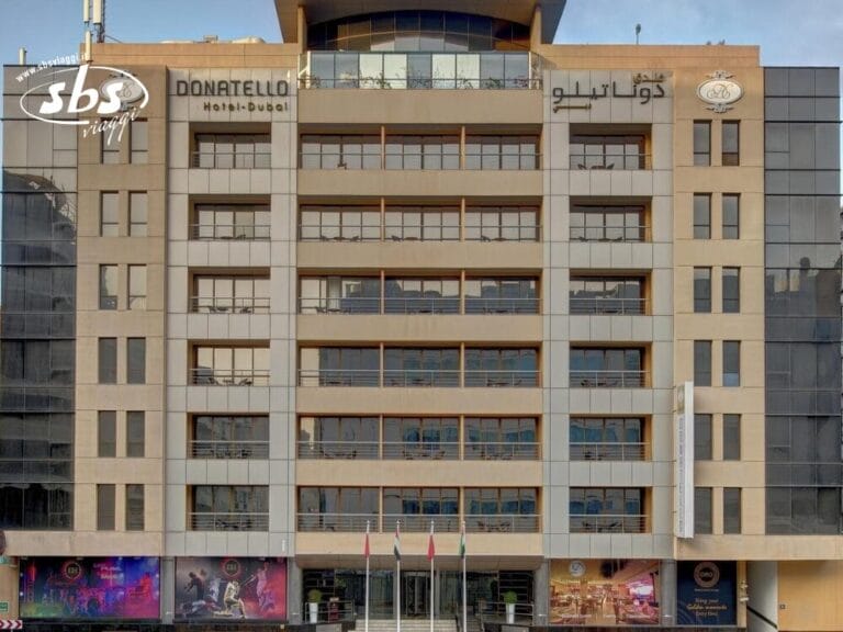 Vista frontale del Donatello Hotel di Dubai con i suoi piani multipli, le bandiere all'ingresso e un'atmosfera accogliente catturata in questa elegante Bozza automatica.