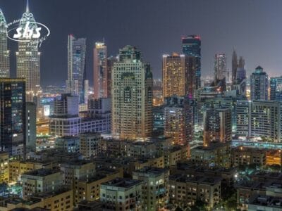 Vista notturna dello skyline di una città con grattacieli e finestre illuminate, caratterizzata da un'architettura moderna e un pizzico di atmosfera da Bozza automatica.