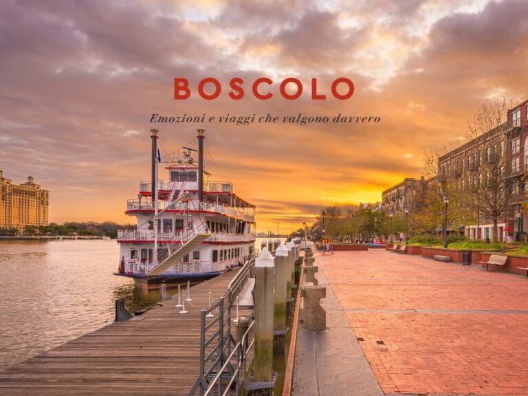 Un battello attraccato al tramonto con sopra scritto “BOSCOLO Emozioni e viaggi che valgono davvero”, che evoca il fascino dei viaggi attraverso la Georgia o l'Azerbaigian.