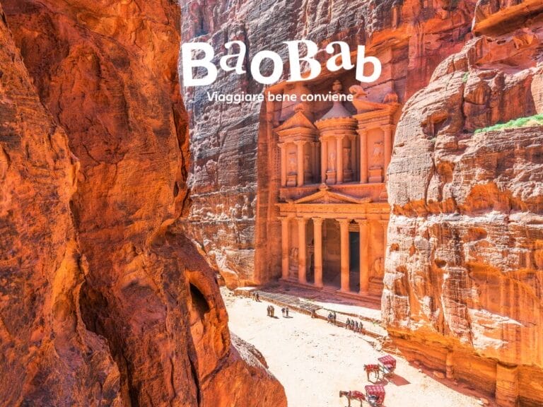 L'antica facciata scolpita nella roccia di Petra in Giordania, con turisti e cammelli in basso. Il logo "Baobab" in alto, che invita a scoprire le meraviglie che la Giordania ha da offrire.