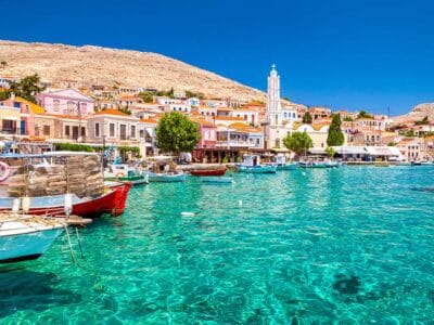 Le barche ormeggiate sulle limpide acque turchesi di un colorato villaggio costiero della Grecia.